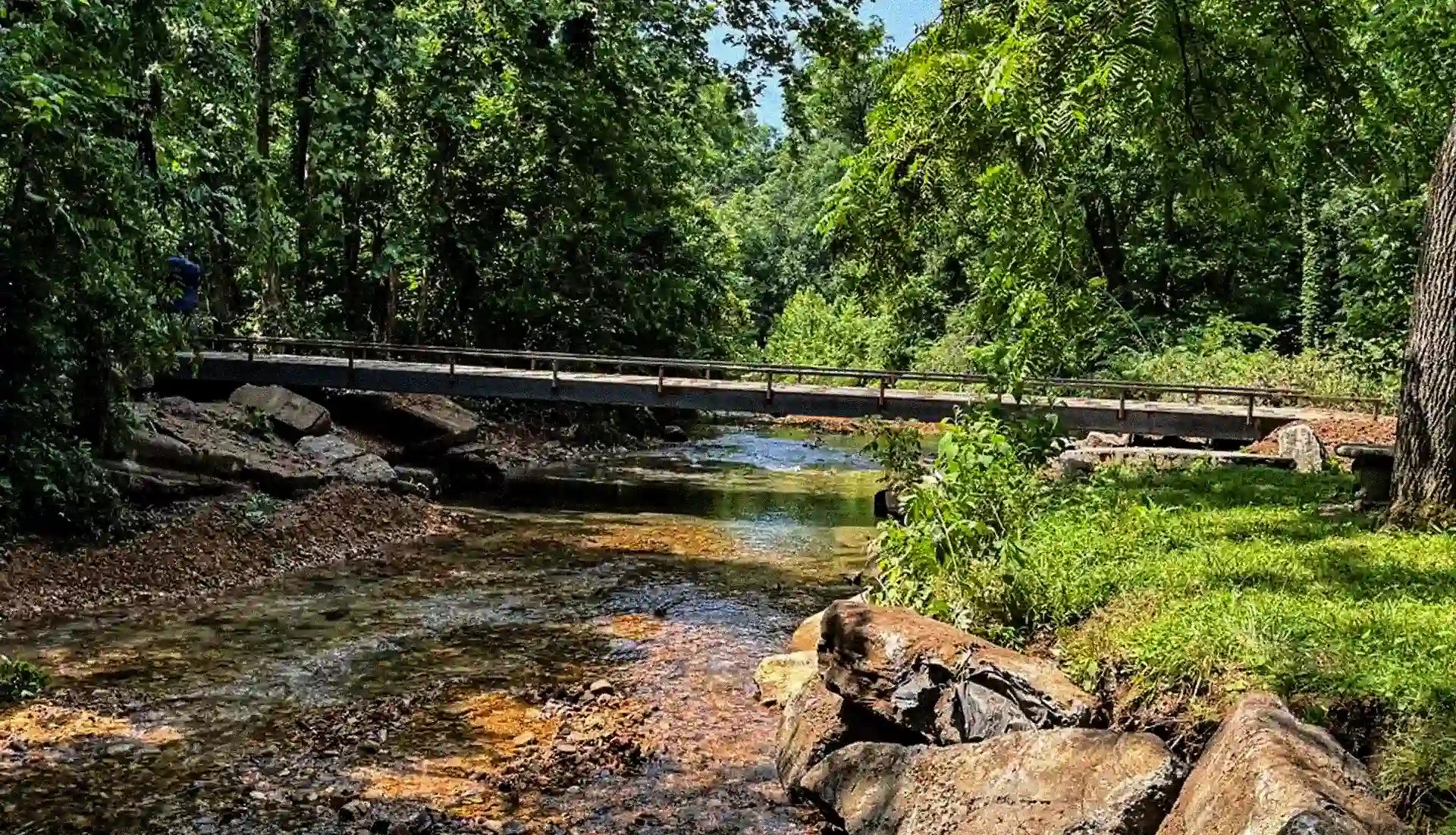 portable steel bridge over a stream in a wooded area