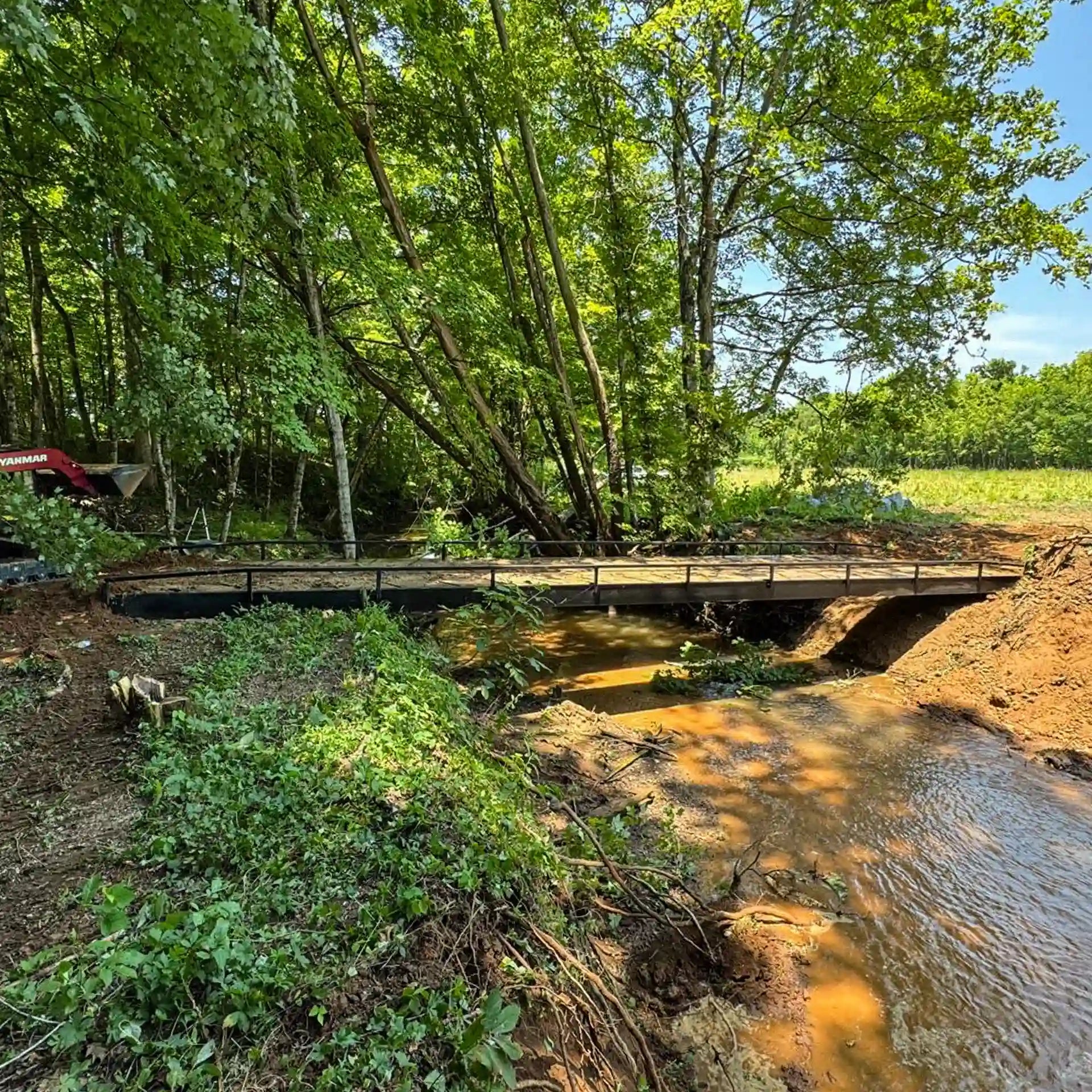 portable steel bridge over a stream in a wooded area