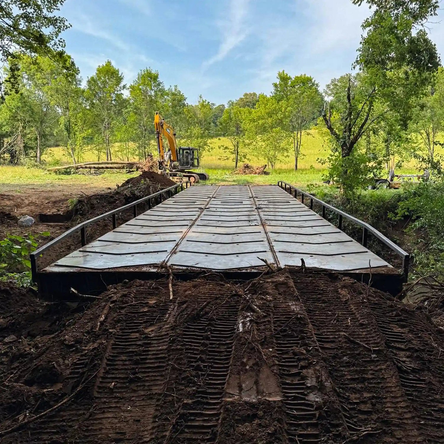 portable steel bridge over a stream in a wooded area
