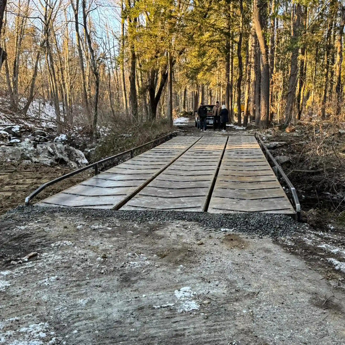 portable steel bridge over a stream in a wooded area