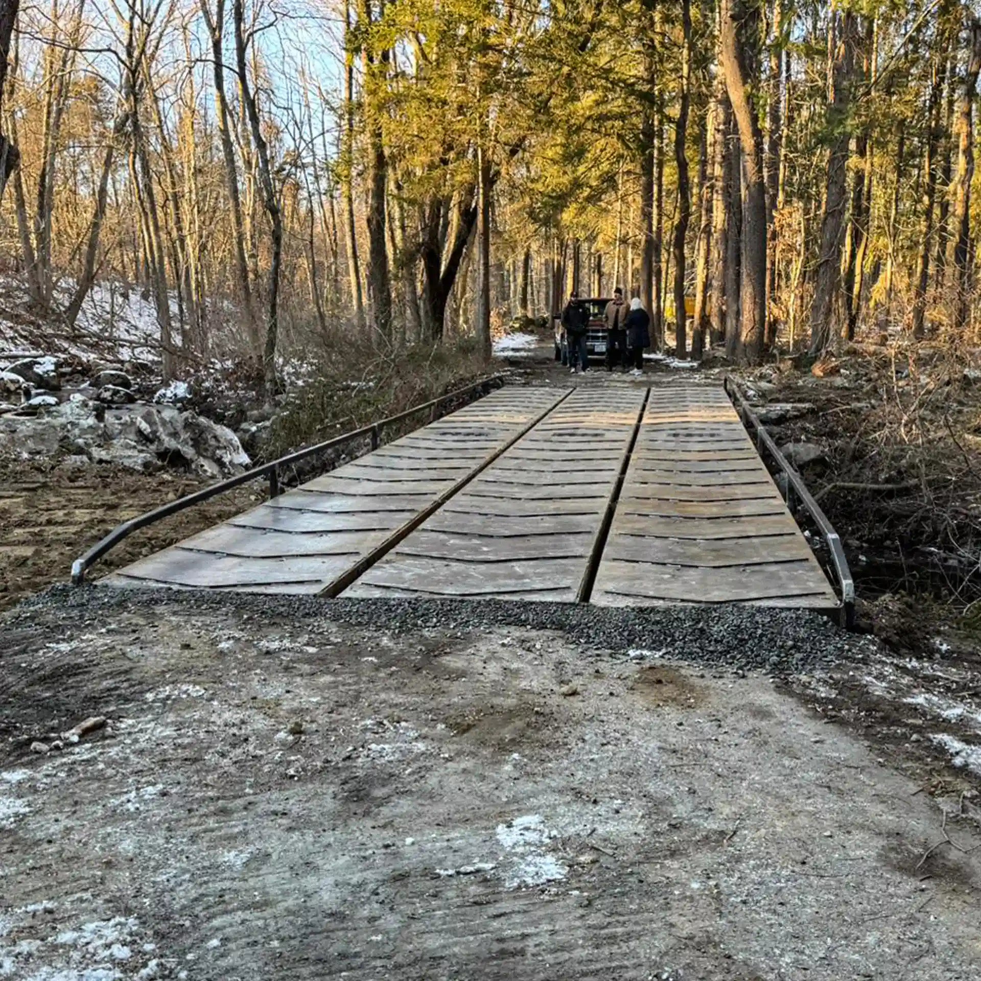 portable steel bridge over a stream in a wooded area