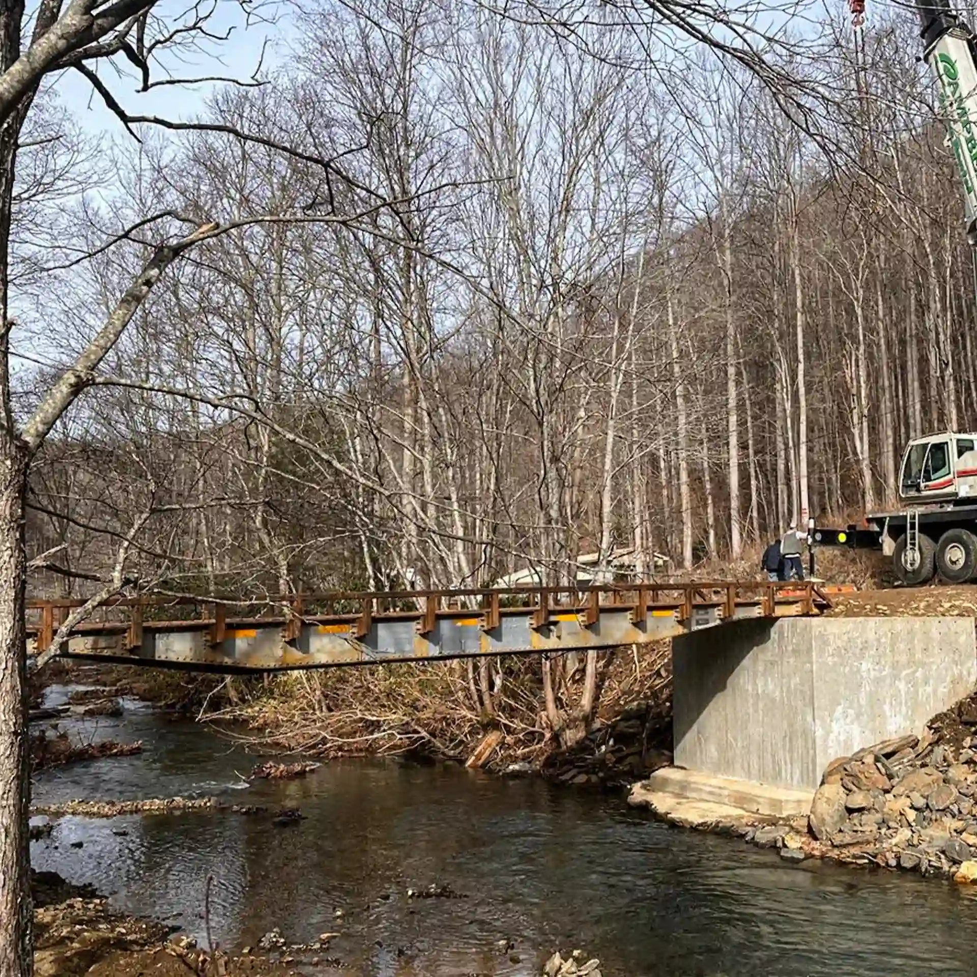 Construction site with a rail car bridge over a stream in a forested area
