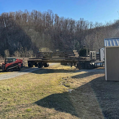 trailer with portable steel bridge components in a wooded area