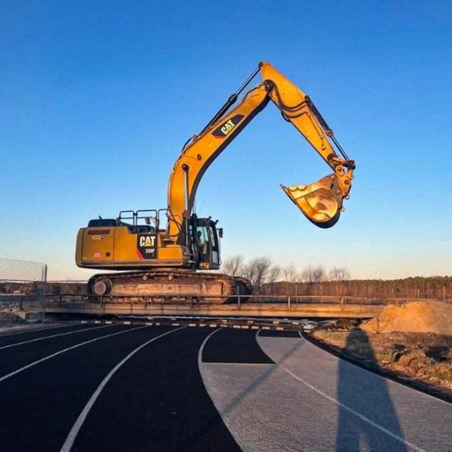 excavator on a portable steel bridge over a track