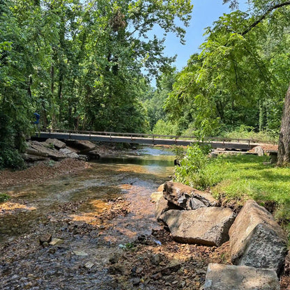 long portable steel bridge over a stream in a wooded area