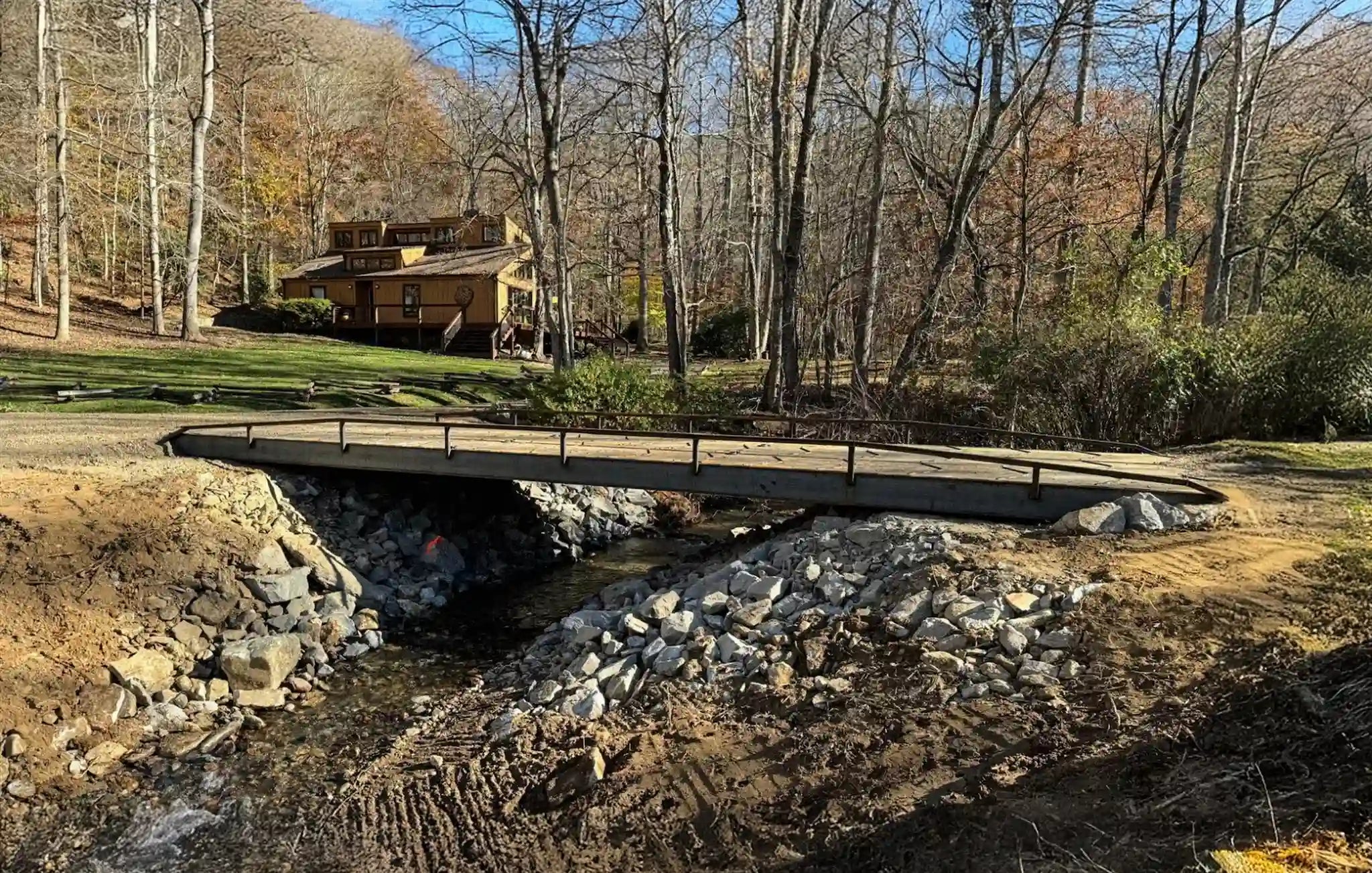 portable steel driveway bridge over a stream in a wooded area