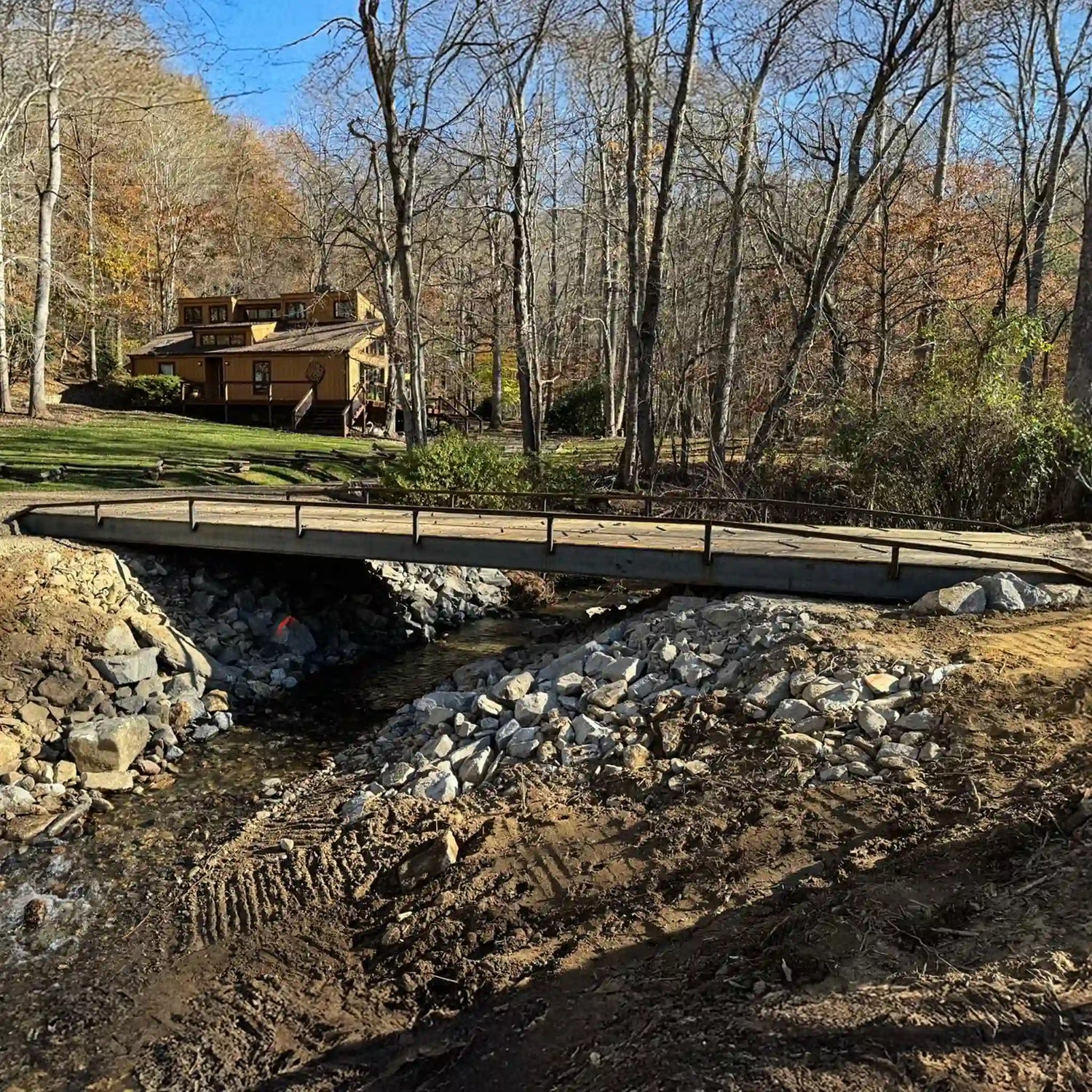 portable steel bridge driveway over a stream in a wooded area