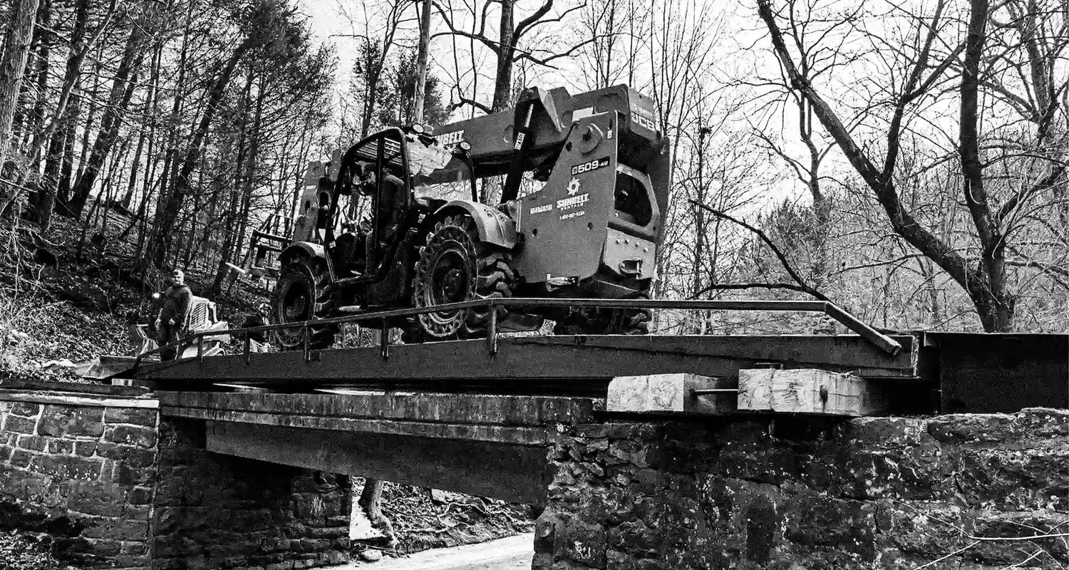 industrial equipment on a portable steel bridge in a wooded area