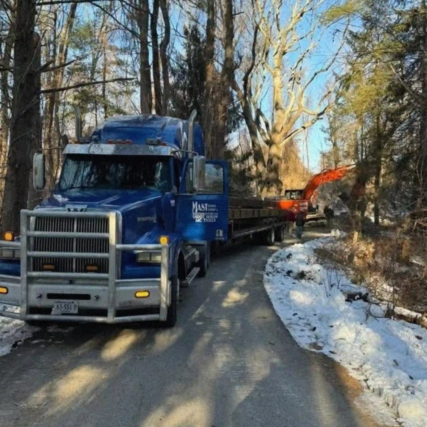 truck trailer of steel bridge components in a wooded area