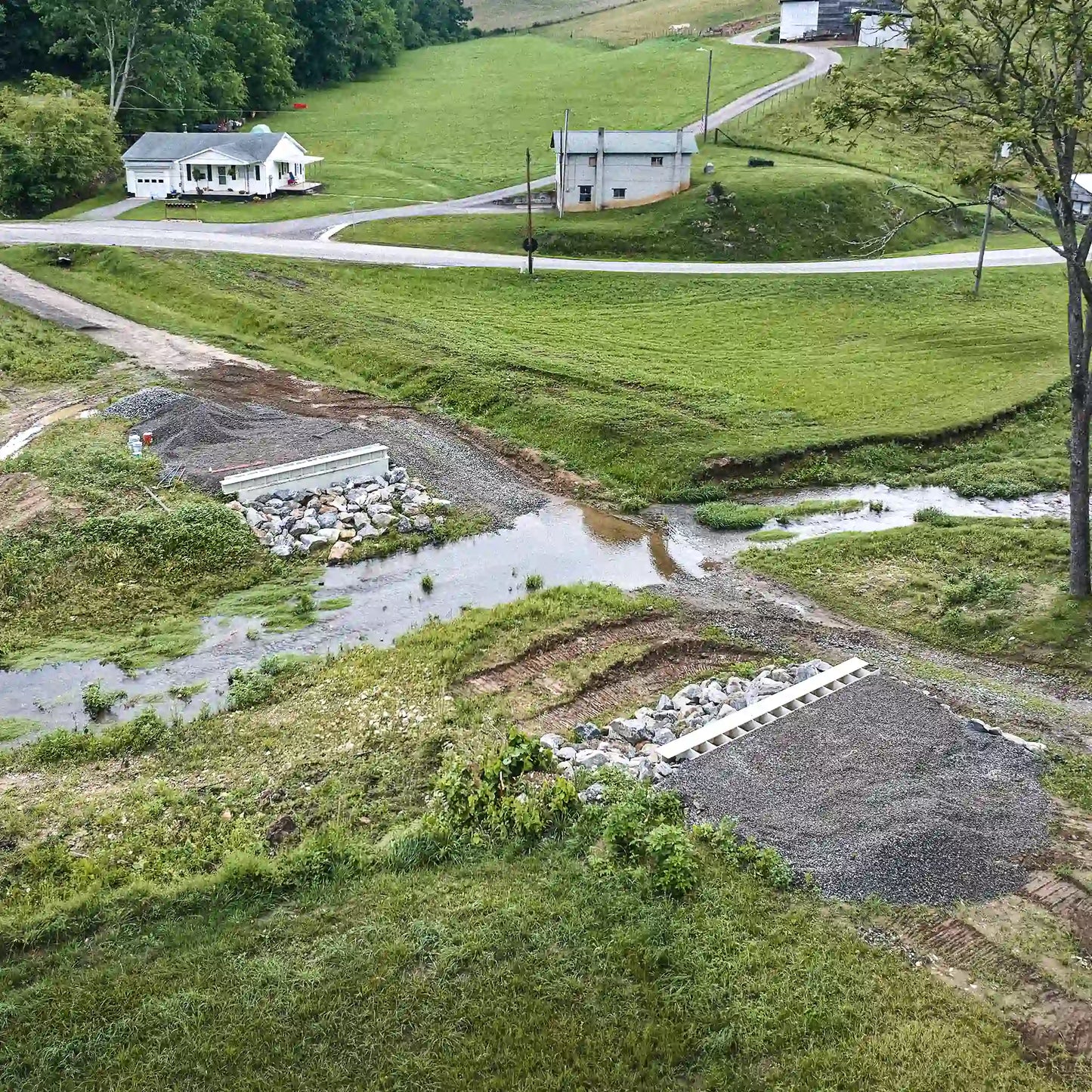 Aerial view of creek crossing prepared for modular steel bridge installation