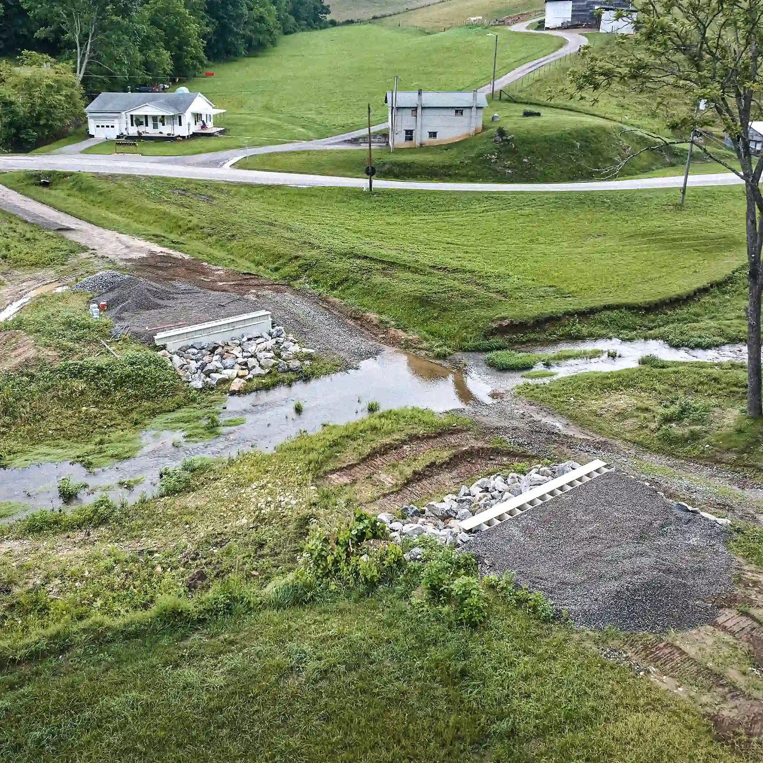Aerial view of creek crossing prepared for modular steel bridge installation