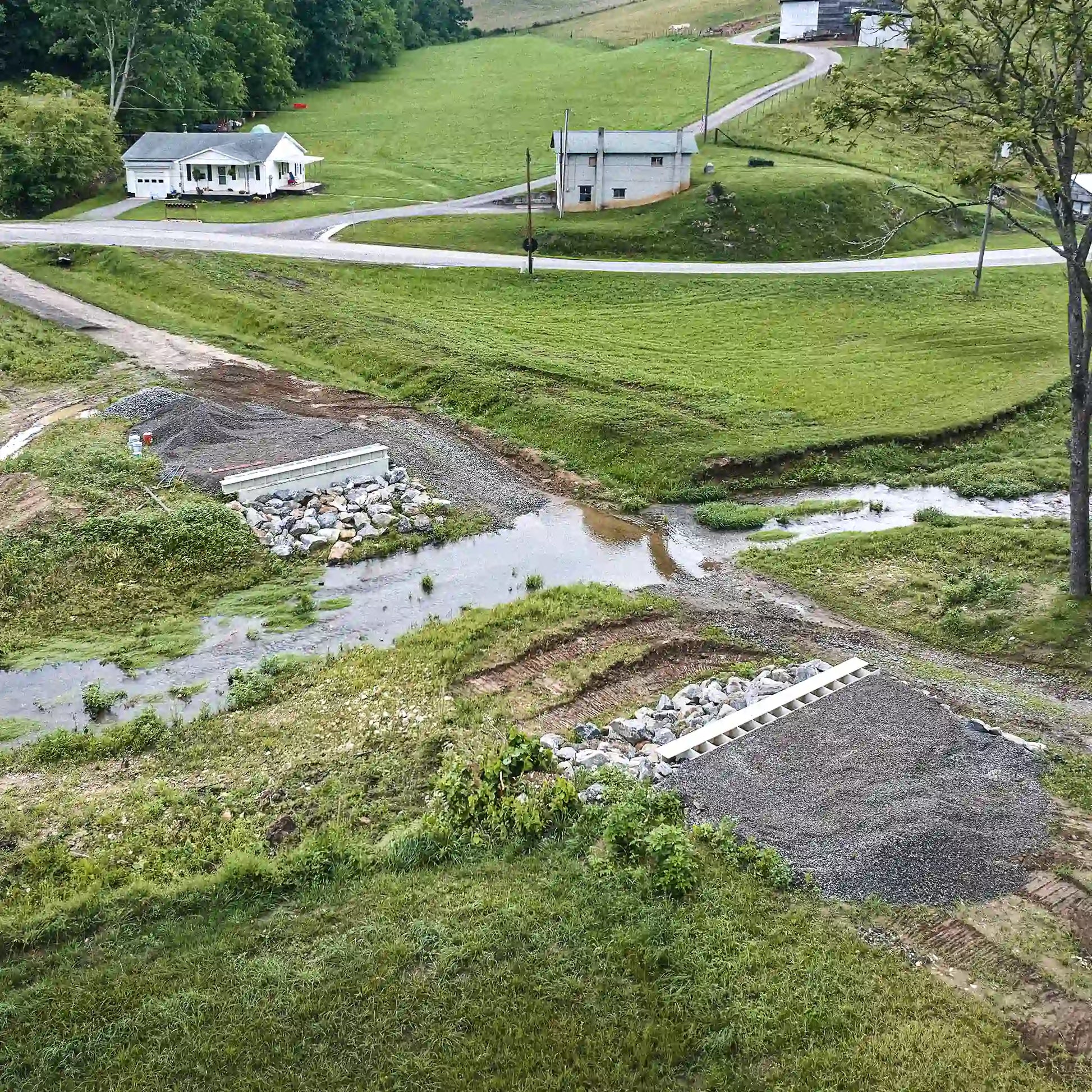 Aerial view of creek crossing prepared for modular steel bridge installation