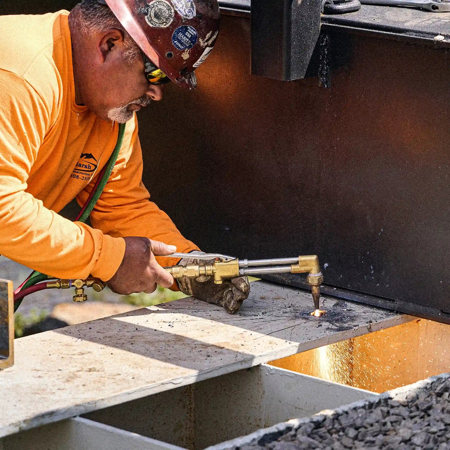 Worker cutting a steel bridge component during modular bridge installation