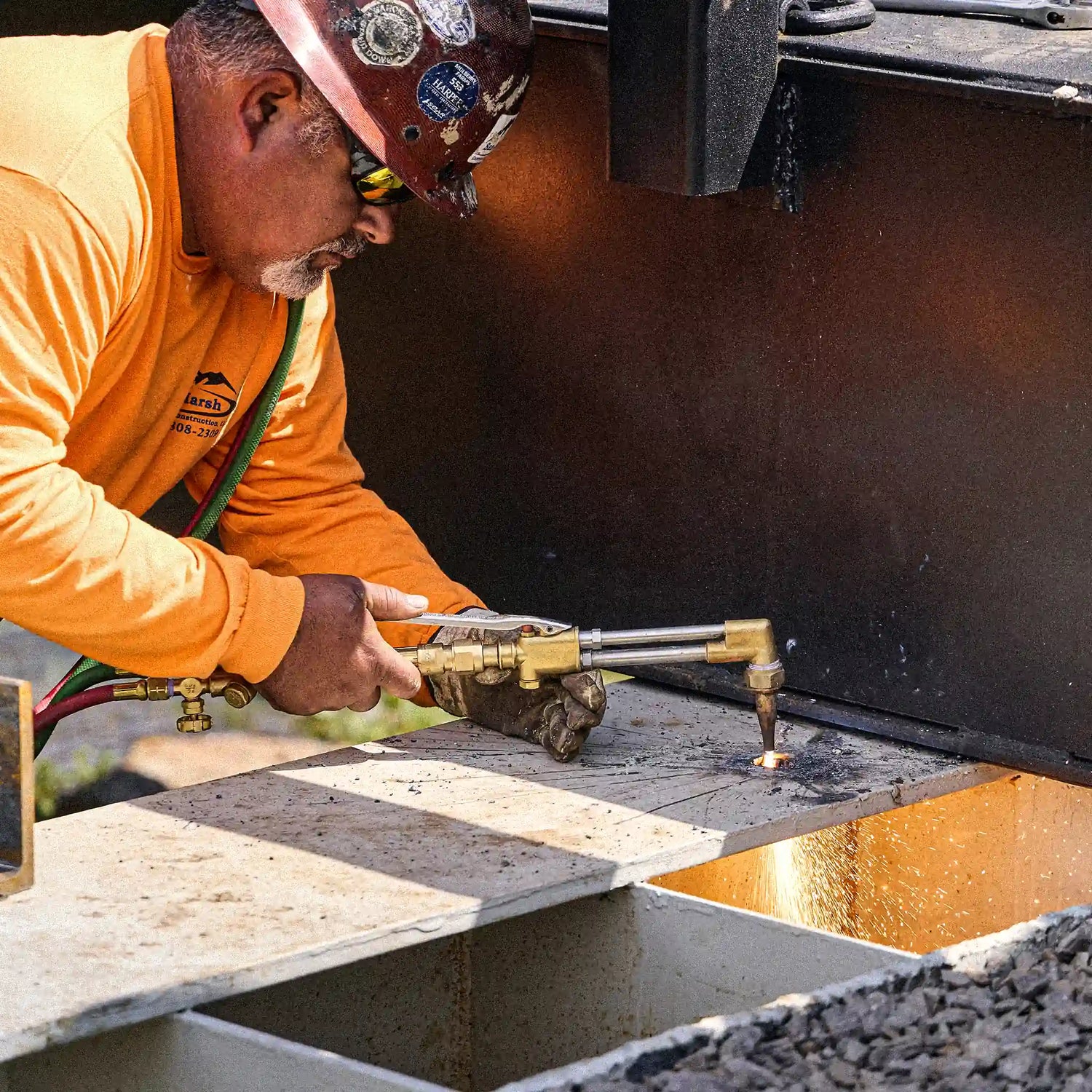 Worker cutting a steel bridge component during modular bridge installation