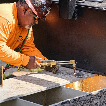 Worker cutting a steel bridge component during modular bridge installation