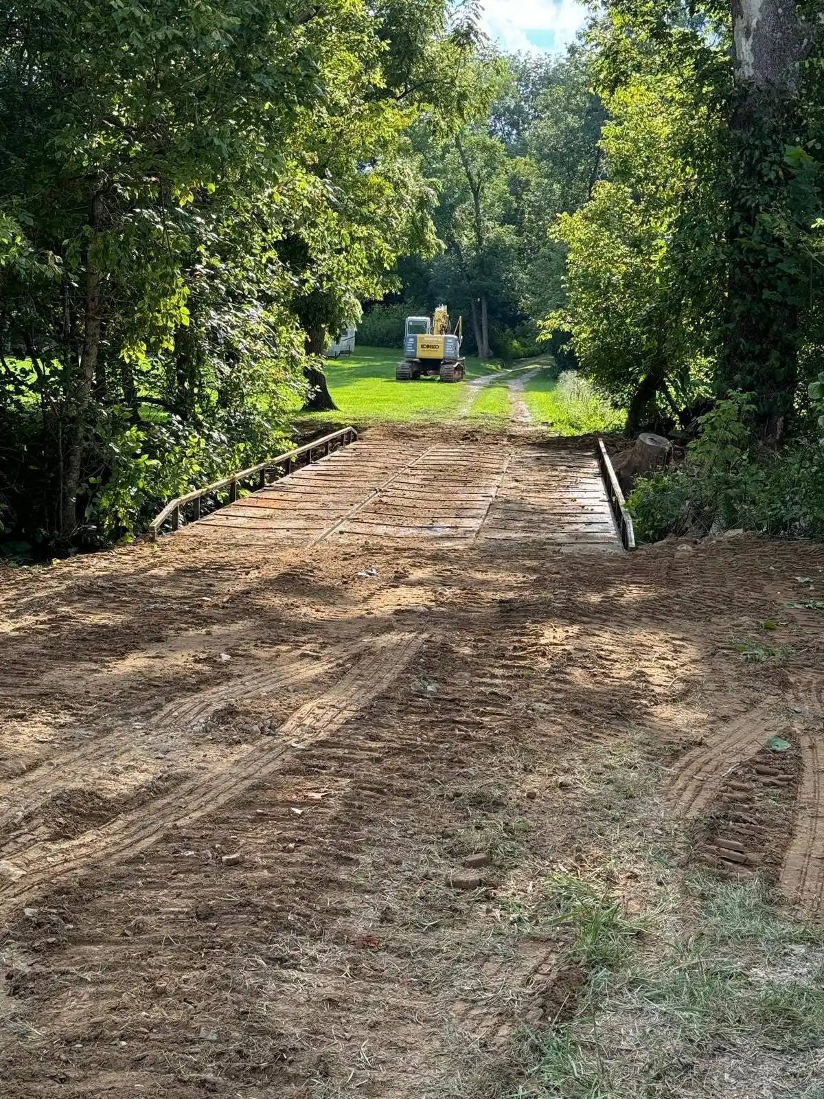 portable steel bridge over a stream in a wooded area