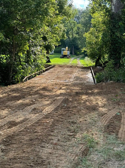 portable steel bridge over a stream in a wooded area