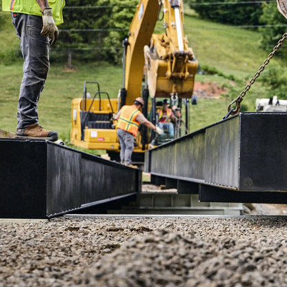 Modular bridge section being set onto a concrete abutment