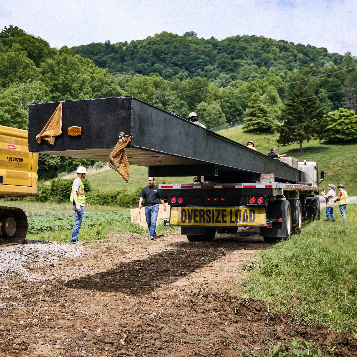 Oversized load truck delivering a long modular steel bridge section