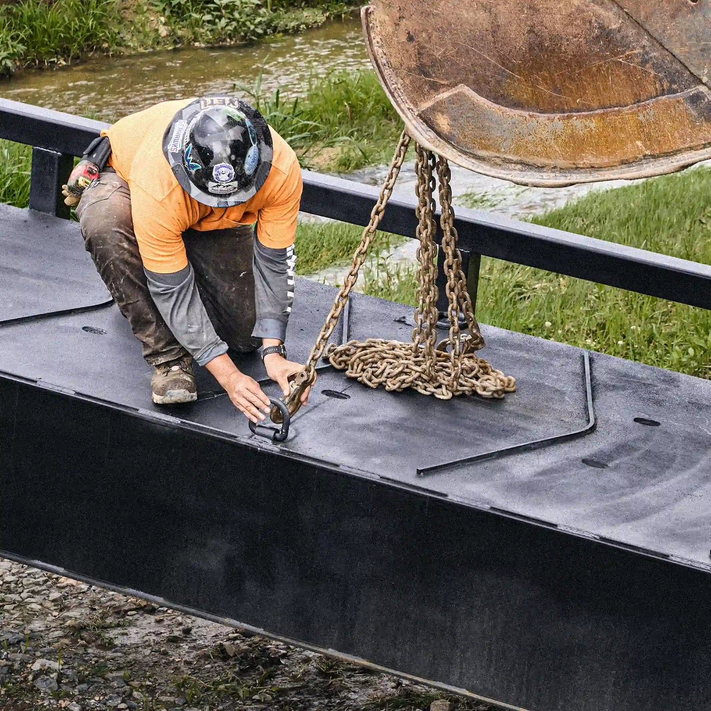 Worker connecting lift chains to a modular steel bridge deck