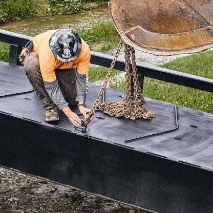 Worker connecting lift chains to a modular steel bridge deck