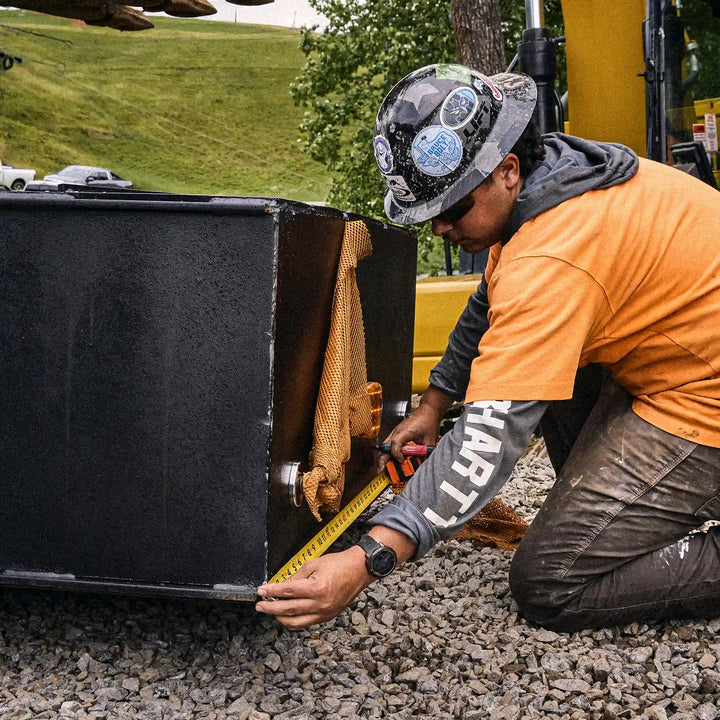 Worker measuring a steel bridge beam during modular bridge installation