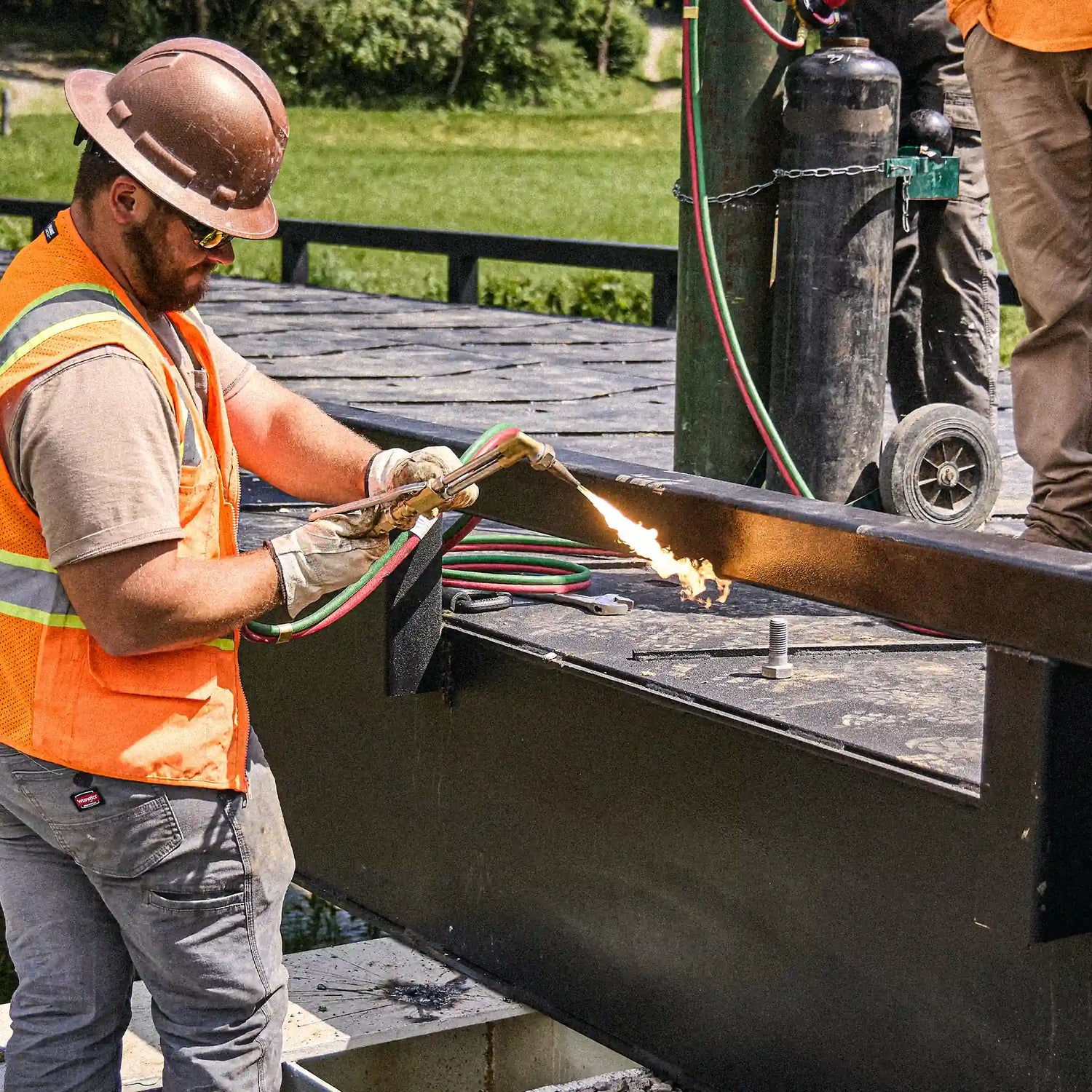 Worker welding a steel beam for a modular bridge installation