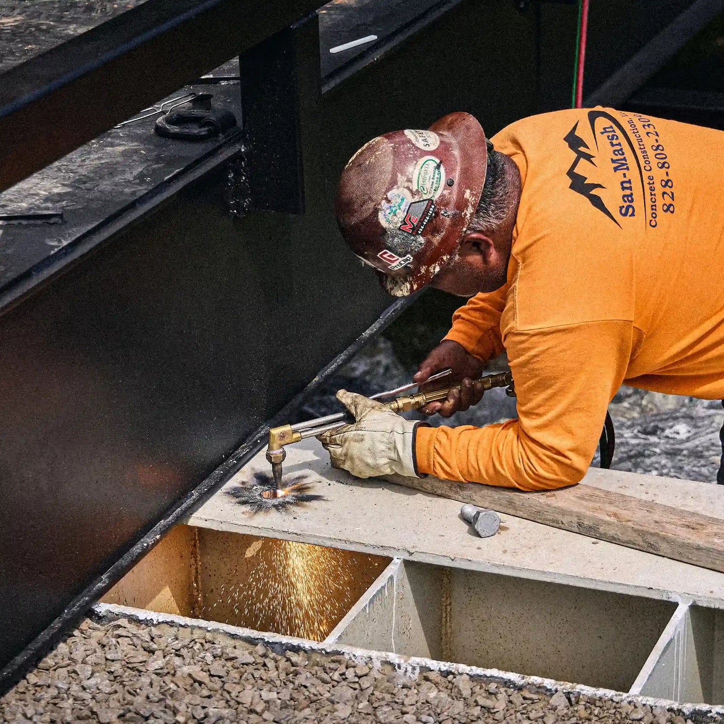 Worker welding a steel bridge beam during modular bridge installation